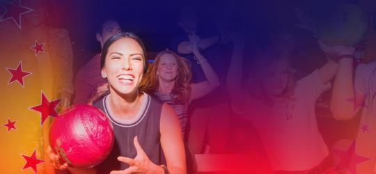 woman holding bowling ball with crowd behind her